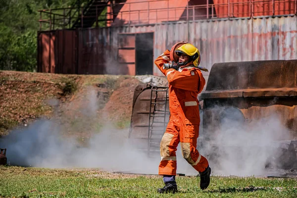 Professzionális Tűzoltó Sétál Füsttel Töltött Környezetben Miközben Tartja Tűzoltó Tömlő Stock Kép
