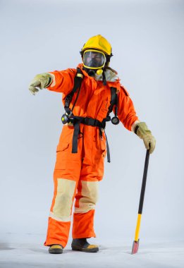 Profesyonel itfaiyeci demir baltayla zemini sabitlerken, yanlarını parmağıyla işaret eder..