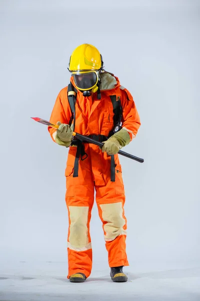 消防士は 鉄斧を慎重に検討することで 全体的な準備に効果的に貢献する装置を維持し活用するという彼のコミットメントを示しています — ストック写真