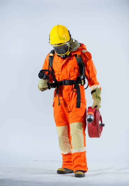 頭を下げ 白い背景に消防ホースを保持している黄色のヘルメットを身に着けているプロの消防士 — ストック写真