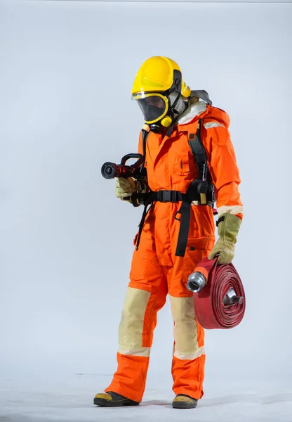 決定的な焦点で 消防士は消火活動に不可欠な強力なツールを管理するための専門知識を示す消防ホースに強く 安定したグリップを維持します — ストック写真