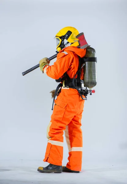 彼の背中に酸素タンクを持っている間側面図では プロの消防士は立っていると彼の肩に鉄斧を保持しています — ストック写真