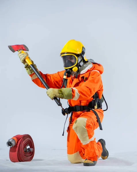 鉄斧を持つ消防士の膝の姿勢と鉄斧の組み合わせは 彼らの任務に積極的かつ常に警戒することへのコミットメントを強調しています — ストック写真