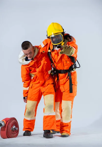 プロの消防士は彼のパートナーが彼らの消防活動によって引き起こされる疲労を軽減するために慰めと援助を提供するのを助ける — ストック写真