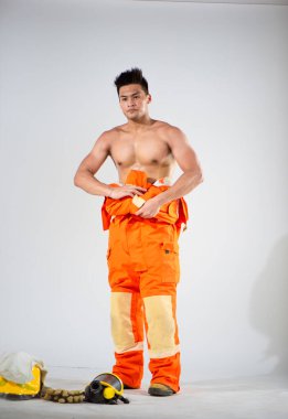 Alıştırmalı kolaylıkla itfaiyeci elbiseyi ustalıkla beline bağlar. Bu, detaylara ve profesyonel görünümü korumaya olan bağlılığını gösteren bir jest..