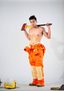 Profesyonel itfaiyecinin omzuna demir baltayı dayayarak güçlü bir dayanıklılık ve hazır olma görüntüsü oluşturur..