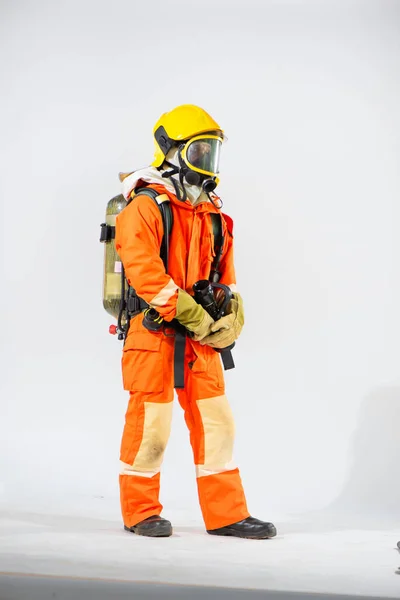 手と白い背景に彼の背中に酸素タンクを着用して火災ホースを保持立って黄色のハード帽子を身に着けているプロの消防士 — ストック写真