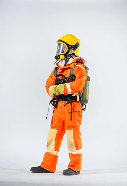 両手で火災ホースを保持立って黄色のハード帽子を身に着けている消防士 — ストック写真