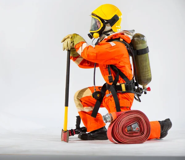 消防士は腰に酸素タンクを持っている間に床を支えるために鉄斧を持って座っています — ストック写真