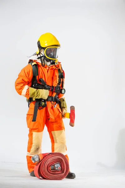 黄色い硬い帽子と鉄斧を持つ保護マスクを持つ消防士と白い背景に地面を見てください — ストック写真