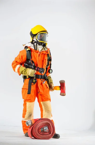 黄色いハード帽子と保護マスクを持つ消防士は コピースペースに向かって白い背景に鉄斧を保持しています — ストック写真