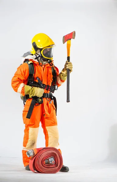 黄色のハード帽子と白い背景に鉄斧を保持し 見て保護マスクを持つ消防士 — ストック写真