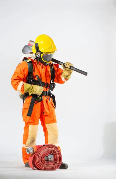 消防员头戴黄色硬礼帽 头戴面罩 肩膀上架着斧头 俯瞰着地面白色背景的侧面景象 — 图库照片