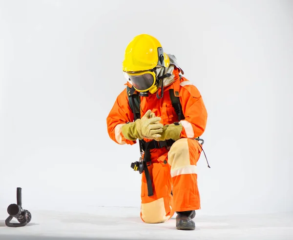 Пожежник Колінах Тримає Руку Дивиться Пожежний Шланг Білому Тлі — стокове фото