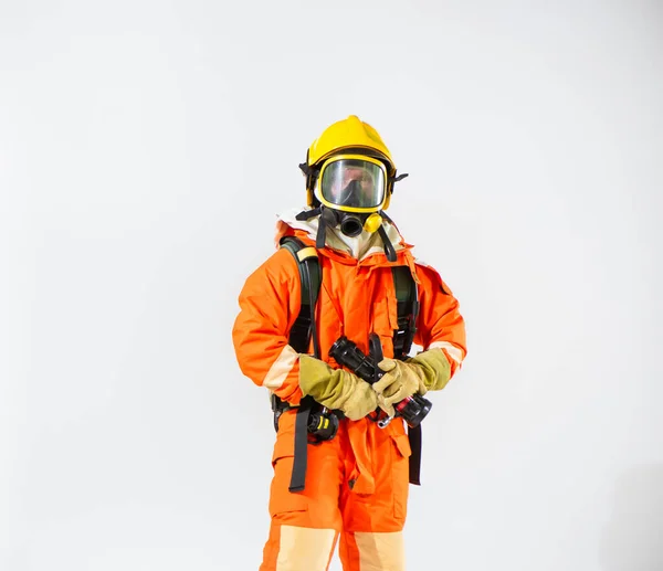 黄色のヘルメットを身に着けている消防士白い背景の上を見ながら両手で消防ホースを保持して立つ — ストック写真