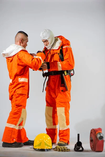 2人の消防士が消防の安全を最優先に着用の兆候と涙のマスクを検査します — ストック写真