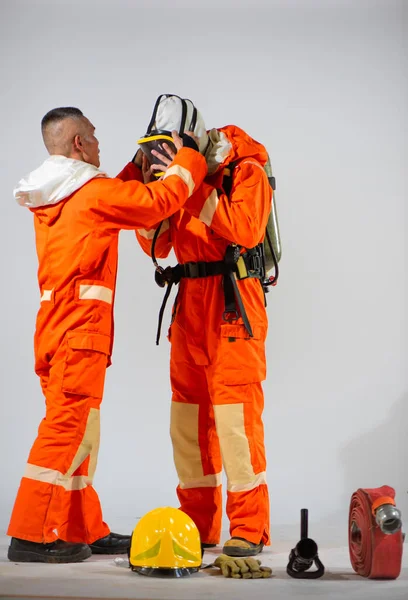 Profesjonalny Strażak Pomaga Swojemu Partnerowi Zoptymalizować Swoją Maskę Białym Tle — Zdjęcie stockowe