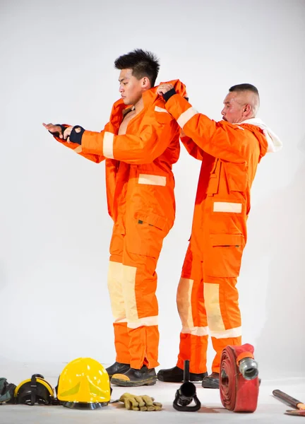 Bombeiros Profissionais Vestindo Uniforme Enquanto Seu Parceiro Ajudou Fundo Branco — Fotografia de Stock
