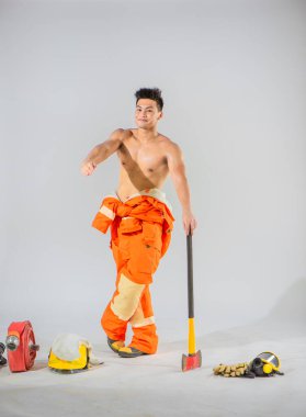 İtfaiyeci sağlam bir baltayla zemini destekliyor ve sıcak bir gülümseme takınarak her türlü itfaiye olayına hazır olduğunu gösteriyor..