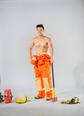 Cesur itfaiyeci beyaz arka planda demir bir baltayla zemini destekliyor..