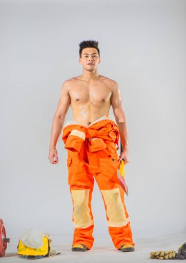 Demir balta tutan üstsüz profesyonel itfaiyeci cesaret ve güven duygusu yayıyor.