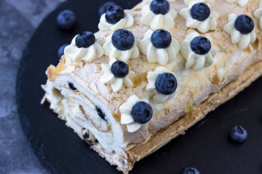 Lezzetli kremalı pasta rulosunun en üst görüntüsü. Yaban mersinli protein tatlısı.