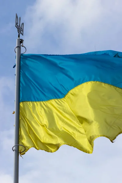 The flag of Ukraine waving in the wind. Blue-yellow flag with coat of arms