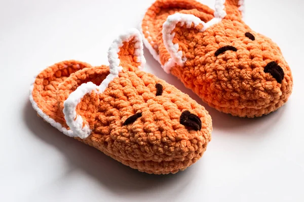 Top view of the bright children\'s slippers. Knitted slippers in the form of a fox. Space for text.