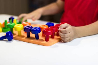 Beyaz arka planda plastik mantar oynayan çocuk kalemleri.