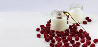 Ahududulu ev yapımı yoğurt. Ahududu dolu yoğurt kavanozları. Metin için boşluk