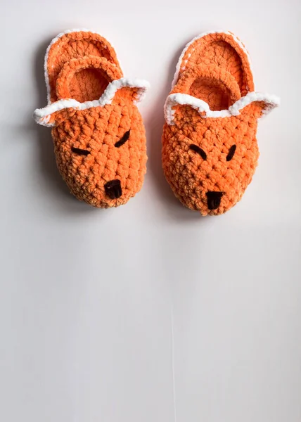 Top view of the bright children\'s slippers. Knitted slippers in the form of a fox. Space for text.