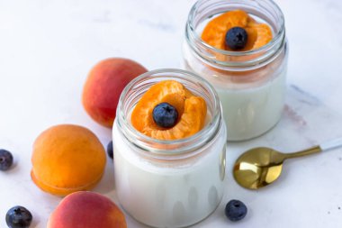 Kayısı ve yabanmersinli ev yapımı yoğurt. Yukarıdan, beyaz arkaplanda görüntüle