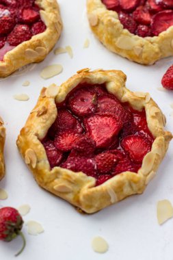 Çilekli mini bisküviler. Beyaz arkaplanda küçük meyveli turtalar.