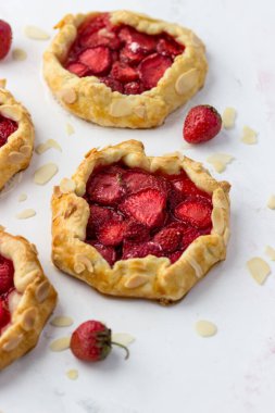 Çilekli mini bisküviler. Beyaz arkaplanda küçük meyveli turtalar.