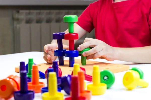一个孩子在玩彩色塑料构造函数的侧视图 大楼炮塔 — 图库照片