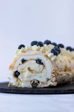 Siyah tabakta yaban mersinli krema rulosu. Beyaz arkaplanda tatlı