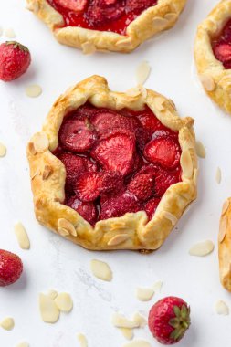 Çilekli mini bisküviler. Beyaz arkaplanda küçük meyveli turtalar.