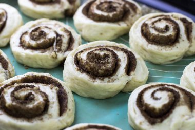 Cinnabon yapma süreci. Tarçınlı hamuru hasırın üstünde yuvarla