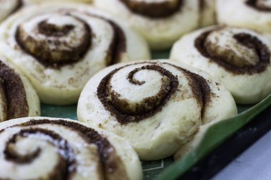 Cinnabon yapma süreci. Tarçınlı hamuru hasırın üstünde yuvarla
