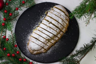 Stollen 'daki Noel ağacı dalları arasından en üst manzara. Siyah tabakta klasik Alman keki.