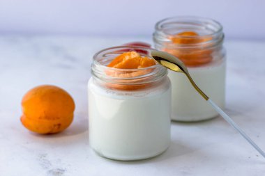 Kayısı ve ev yapımı yoğurt. Beyaz bir masada yoğurt.