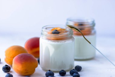 Kayısı ve yabanmersinli ev yapımı yoğurt. Yukarıdan, beyaz arkaplanda görüntüle