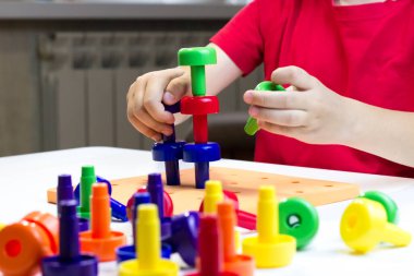 Montessori eğitimi. Renkli mantarlarla oynayan bir çocuk.