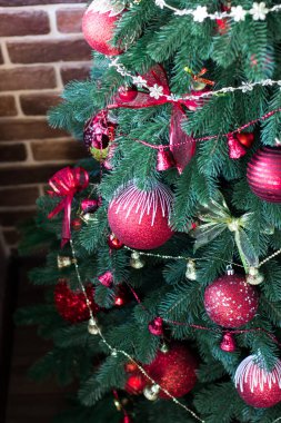 Kırmızı topları ve çanları olan Noel ağacı. Dekor altın ve kırmızıdır. Noel gelenekleri