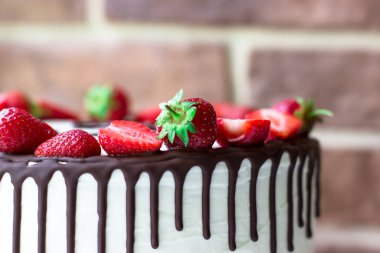 Pastadaki çikolata lekeleri. Krem peynir. Çikolata jöleli. Çilekli pastanın yan görüntüsü