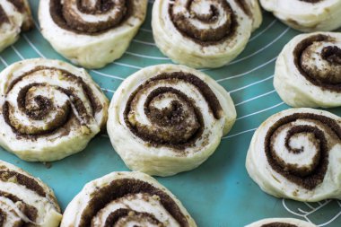 Cinnabon yapma süreci. Tarçınlı hamuru hasırın üstünde yuvarla