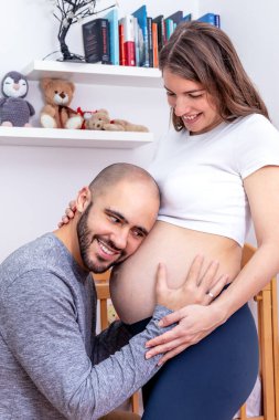 Mutlu bir baba, karısının karnında doğmamış çocuğunu dinlerken mutlu olmasını bekliyor. Sevgili müstakbel ebeveynler.