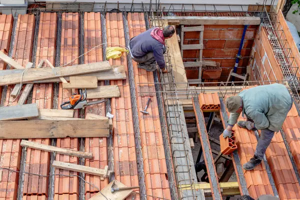 Les Travailleurs Construction Arrangent Les Briques Bâtiment Avant Verser Dalle Image En Vente