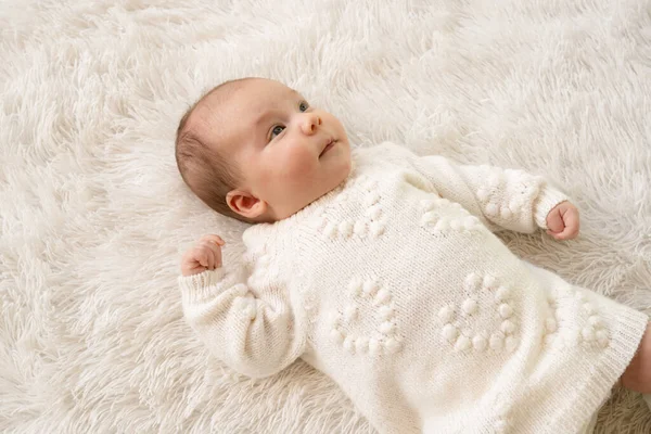 刚出生的女婴睡在柔软的毛毯上 躺在毛毯上 睁开眼睛 穿着白色衣服 — 图库照片