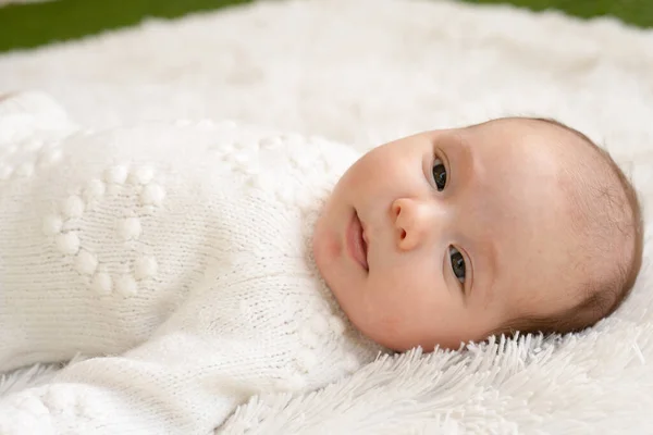 抱着刚出生的女婴睡在柔软的毛毯上 躺在毛毯上 睁开眼睛 穿着白色衣服 — 图库照片